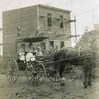 Sepia-tone photo of women & children seated in carriage with horse; house under construction, Hoboken?, n.d., ca. 1905-1910.