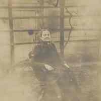 Sepia-tone photo of Mrs. Annette Henry seated in a rocker in the backyard of 716 Bloomfield St., Hoboken, no date, ca. 1890.
