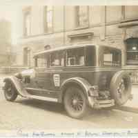 Sepia-tone photo of Hoboken Yellow Cab Co. taxi parked outside Hoboken Police Headquarters, Newark St., between Washington & Bloomfield Sts., Hoboken, March 11, 1933.