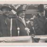 B+W photo of Mayor John J. Grogan (center) & 2 men on reviewing stand, Hoboken City Hall, Hoboken Centennial Parade, March 27, 1955.