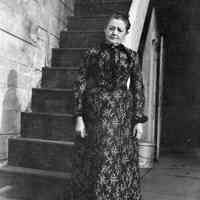 B+W negative image of Mrs. Annette Henry standing near the backyard stairs, no place, no date, ca. 190