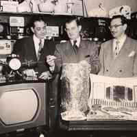 Digital image of b+w photo of Mayor Fred DeSapio selecting a raffle or sweepstake ticket in radio - television store, Hoboken, no date, ca. 1947-53.