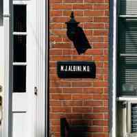 Color photo of house front and sign for M.J. Albini, 204 Fifth St., Hoboken, Sept., 1-5, 2001.