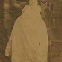 Sepia-tone photo of an unidentified baby in christening clothes, posed in studio, Hoboken, n.d. ca. 1889-1892.