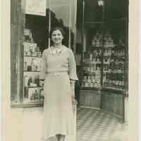 Sepia-tone photo of a woman posed in front of the exterior of Baron