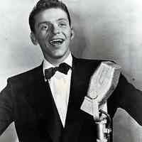 Black-and-white publicity photo of a young Frank Sinatra in black dinner jacket & bowtie at a microphone, no place, no date, probably Dec., 1942.