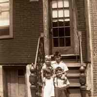 Black-and-white negative of three boys and a girl posed on a front stoop, Hoboken, no date, ca. 1930-40.