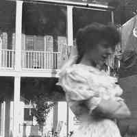 B+W negative image of unidentified woman in a backyard, laundry on the clothesline, no place, no date, ca. 190