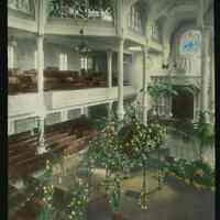 Lantern slide, color, of a church interior with floral decorations, used for promotional display in Hoboken, no date, ca. 1920.