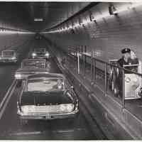 B+W photo, 2, of Port Authority officer in catwalk car, Lincoln Tunnel, Aug. 25, 1960