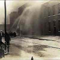 Sepia-tone photo of exterior view of a fire at John Schmalz