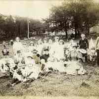 Sepia-tone photo of large group of women and children posed on a lawn, n.p., n.d. (ca. 1892-1900).