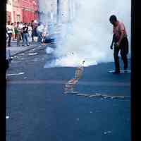 Color slide of firecrackers being set off on a street.