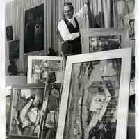 B+W photo of Clam Broth House owner John Podesta hanging paintings in the restaurant, Hoboken, December 16, 1961.