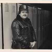 B+W photo of Hoboken Police officer Tom Meehan near some lockers, Hoboken, n.d, ca. 1983-1988.