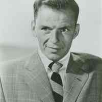 Black-and-white photo of Frank Sinatra in a check jacket and striped tie, no place, no date, ca. 1950.