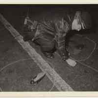 B+W photo of Hoboken police officer marking a crime or accident scene, Washington St., Hoboken, n.d, ca. 1983-1988.