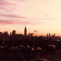 Digital scan of color photo of a sunrise view of the Manhattan skyline from Jersey City Heights, Jersey City, no date, circa 1970-1980.