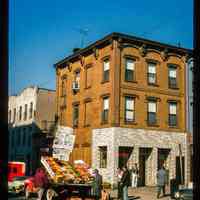 Color slide of eye-level view of street scene with a produce truck and an unidentified building on the corner of Washington and 5th