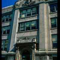          Color slide of eye-level view façade, portico, pediment and frieze reading 