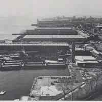 Reference image of printed photo image of aerial view of waterfront looking south from pg 29 of archives catalog 2002.026.0002, Hoboken, ca. 1975.