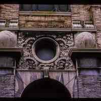 Color slide of detail view of portico keystone, oculi window, pilasters, and capitals of Public School No. 7 building at 80 Park on the SW corner with Newark