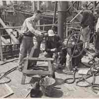 B+W photo of men doing repair work on un-named ship at a Hoboken shipyard, n.d., ca.1960s.