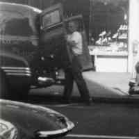 B+W photo of George Kirchgessner with United Decorating Company truck near 220 Washington St. storefront that has been decorated, Hoboken, ca. 1952.