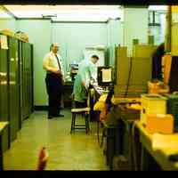 Color slide of men in a lab/office.