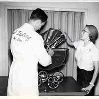 B+W photo of examination of a toy baby (or doll) carriage in U.S. Testing Co. facility, Hoboken, n.d., ca. 1975-1980.