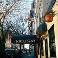 Color photo of hanging sign for Hoboken Furniture, 157 First St. and a canvas marquee for Mulligans Bar, 159 First St., Hoboken, Jan. 3 & 4, 2002