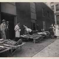 B+W photo of pier fire casualties being treated by Hoboken Red Cross personnel at pier fire, Hoboken, Aug. 11, 1944.