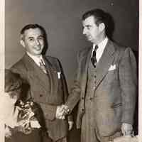 Digital image of b+w photo of Mayor Fred M. DeSapio (right) shaking hands with unidentified man at a luncheon or dinner, Hoboken, no date, ca. 1947-53