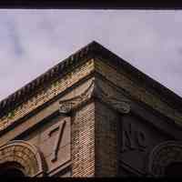          Color slide of detail view of brick pilaster, quoins, gauged arches, dentils and cornice reading 