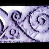 Color slide of snow on wrought iron.