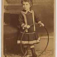 Carte-de-visite of young boy with a hoop in photographer