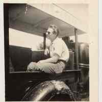 Digital image of b+w photo of Mike Conti seated in back of Lemon Ice & Yum Yum truck at 416 Clinton St., Hoboken, n.d., ca.1950s.