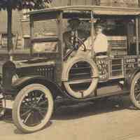          detail of jitney bus to the left; R.B. Davis Baking Powder advertising
   