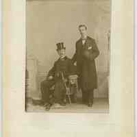 Cabinet photo of 2 men in fine apparel posed in photographer