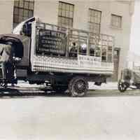 Sepia tone photos, 2, of 2 White Metal Manufacturing Co. trucks patriotically decorated outside factory, n.d., circa 1915.