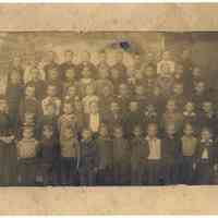 Sepia-toned photo of Mary Cowen (or Cowan) with her class of boys at a school in Hoboken, NJ., ca. 1886-1890.