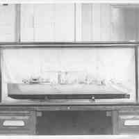 B+W photo of a ship model with camouflage design in a display case, Hoboken, no date, ca 1940-45.