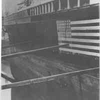 B+W photo of an unknown ship in dry dock with a 48-star flag painted on its side, Hoboken, no date, ca. 1940.