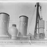 B+W photo of a crated engine part being loaded into or out of an unknown ship, Hoboken, no date, ca. 1940.