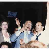 Color photo of mayoral candidate Tom Vezzetti in front of City Hall with supporters on election night, Hoboken, [June 11, 1985].