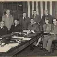 B+W photo of a group of 8 men & a woman posed in a meeting room, Hoboken, no date, probably 1947.