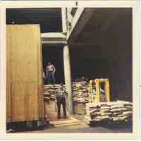 Image: color photo of four longshoremen working with cargo in a pier shed, Hoboken, no date, ca. 1970.