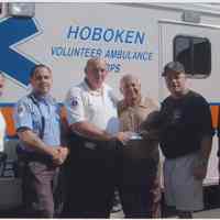 Color photo of Steve Ranuro presenting check to Hoboken Volunteer Ambulance Corps at Biggie