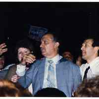 Color photo of mayoral candidate Tom Vezzetti in front of City Hall with supporters on election night, Hoboken, [June 11, 1985].