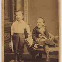 Sepia-tone photo of 2 very young boys posed in photographer